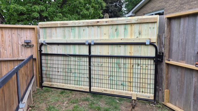 New wood-topped fence gate matched to the existing fence in Moon Township