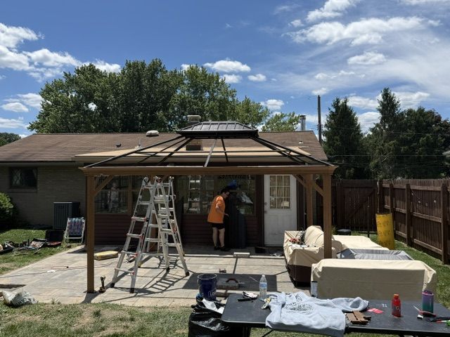 Hardtop gazebo / pergola kit being assembled over a patio in Moon Township