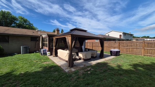 Finished hardtop gazebo / pergola kit with curtains on a backyard patio in Moon Township