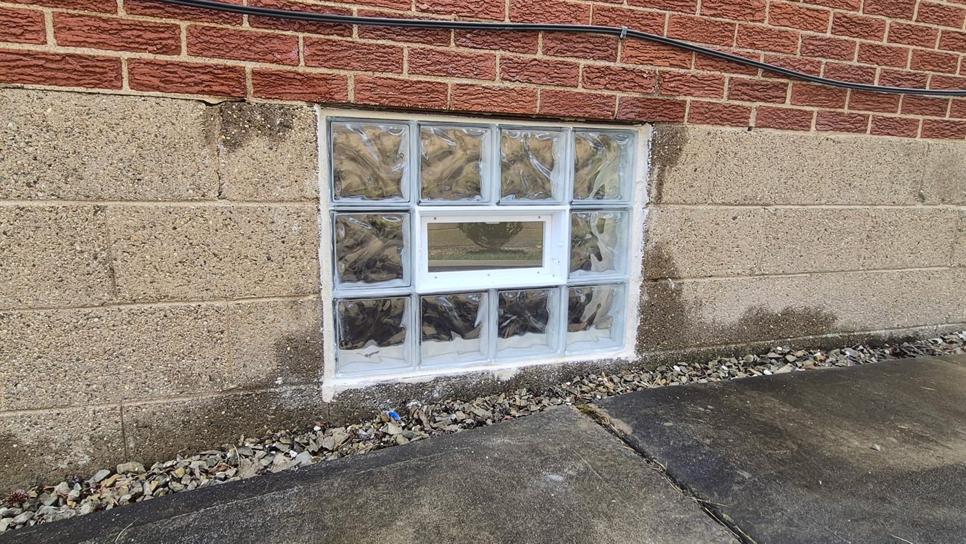 Glass block basement window with a center vent panel installed in a Wexford foundation wall