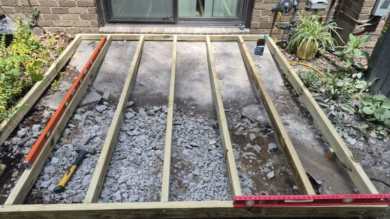 Ground-level deck framing over an old concrete patio in Moon Township before composite decking