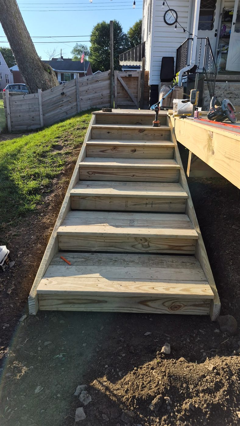 New pressure-treated deck stairs built off a deck in Aliquippa