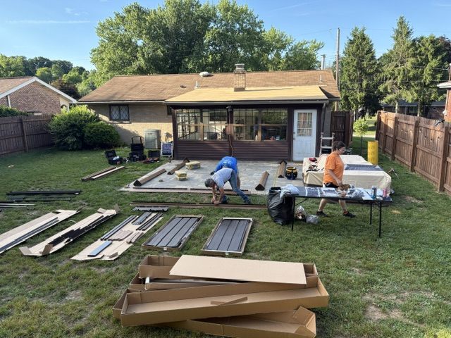 Handled Home crew laying out pergola kit components in a Moon Township, PA backyard at the start of installation.